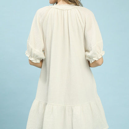White dress with ruffled sleeves on a light blue background