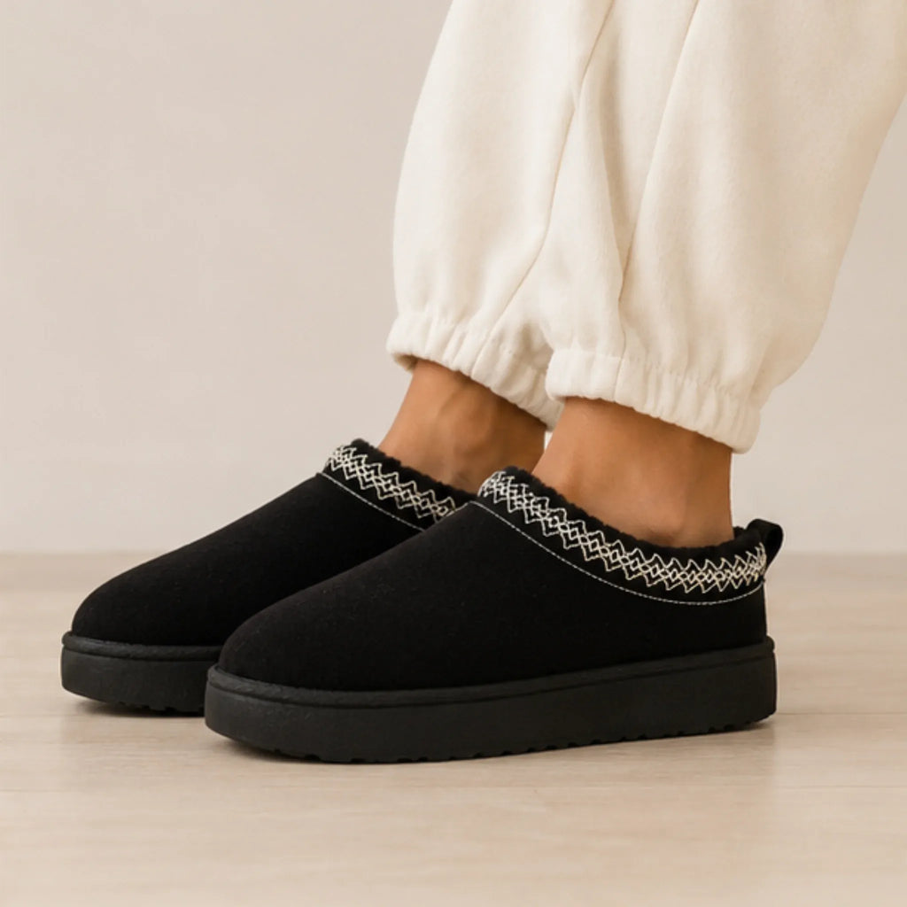 Black Cozy Fleece-Lined House Slippers featuring a soft suede upper, embroidered trim, plush fleece lining, and lightweight platform sole.