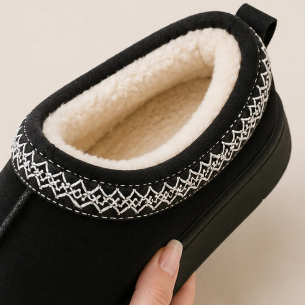 Top view of black Cozy Fleece-Lined House Slippers showcasing the plush fleece interior, embroidered trim, and warm slip-on design.
