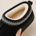 Top view of black Cozy Fleece-Lined House Slippers showcasing the plush fleece interior, embroidered trim, and warm slip-on design.