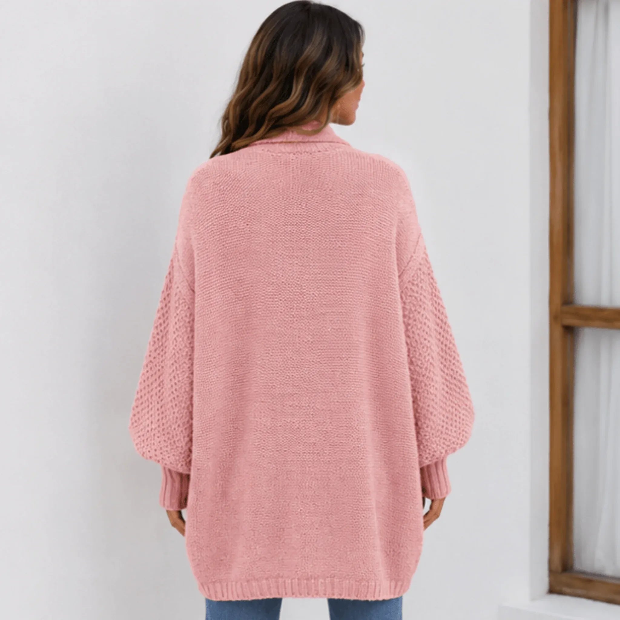 Back view of the women's pink cozy knitted lapel cardigan sweater featuring an oversized silhouette and textured knit finish.