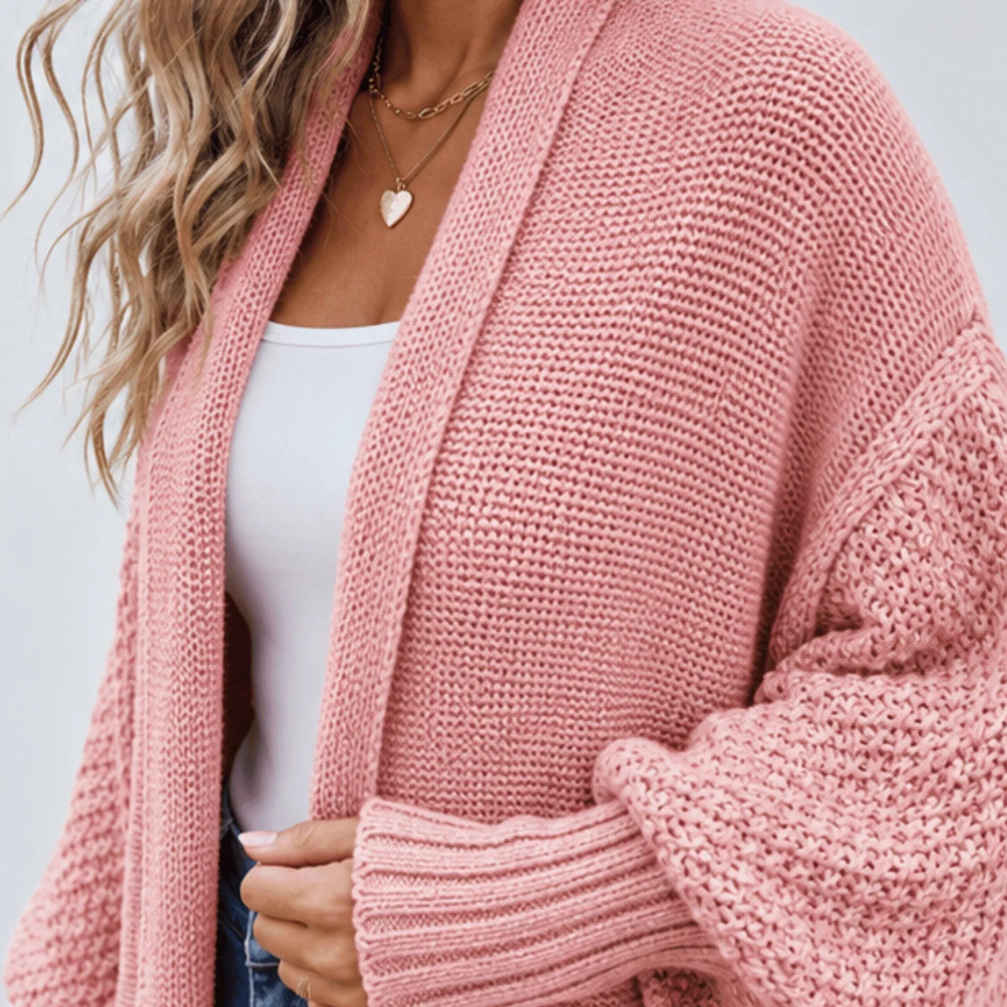 Close-up of the pink cozy knitted lapel cardigan sweater showcasing the textured knit fabric, shawl lapel, and ribbed cuff detail.