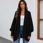 Women's black oversized knitted lapel cardigan sweater with an open front, chunky knit texture, and balloon sleeves.
