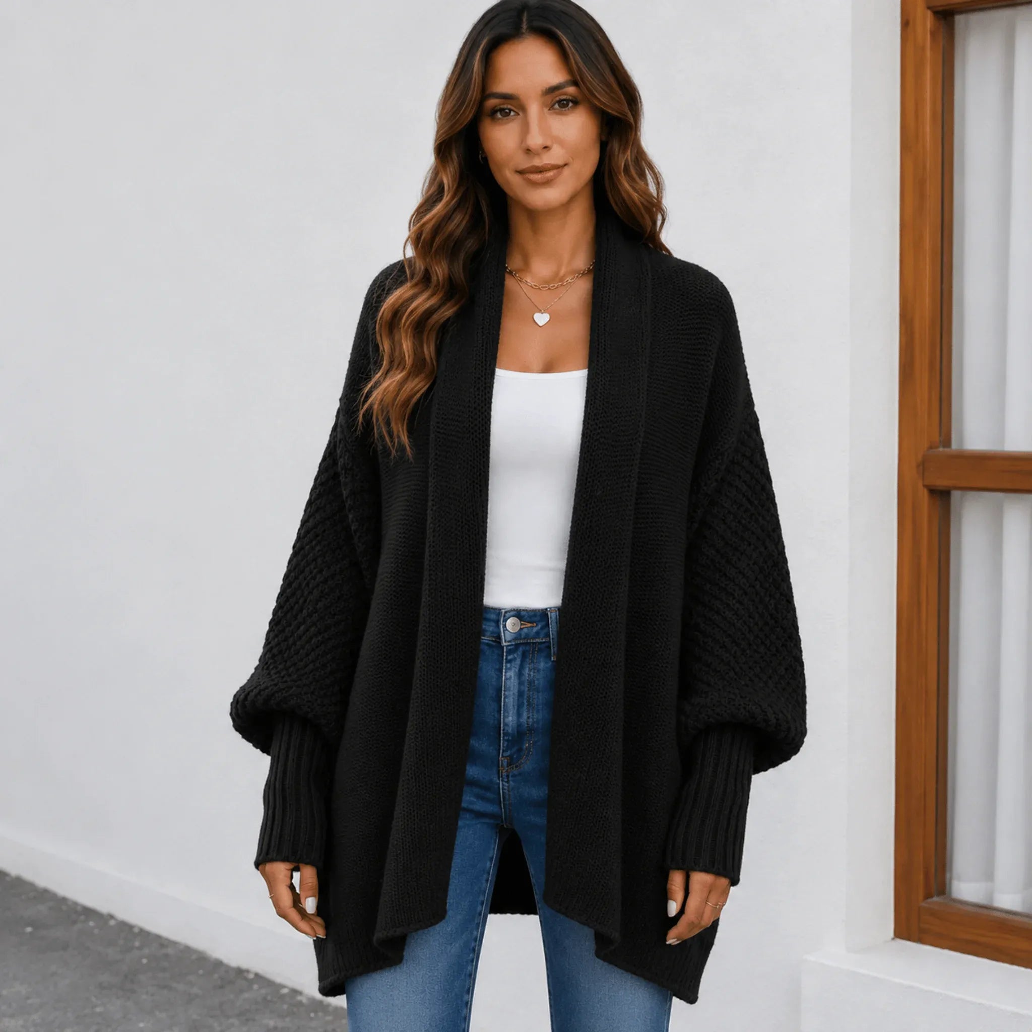 Women's black oversized knitted lapel cardigan sweater with an open front, chunky knit texture, and balloon sleeves.