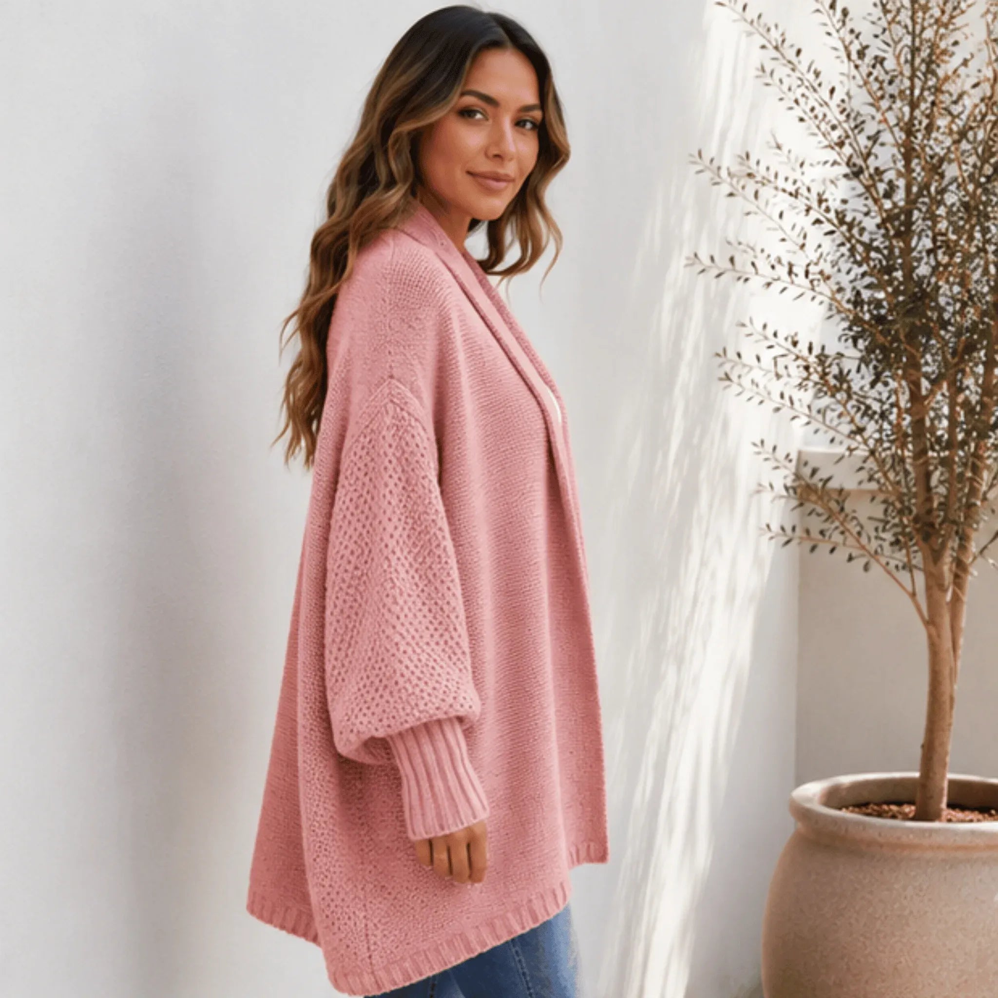 Side view of the women's pink oversized knitted lapel cardigan sweater highlighting its relaxed drape, balloon sleeves, and cozy knit texture.