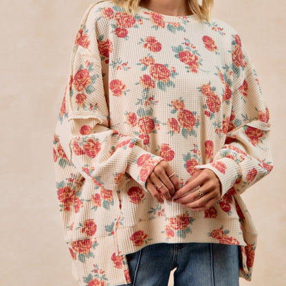 Floral patterned sweater worn by a person on a beige background