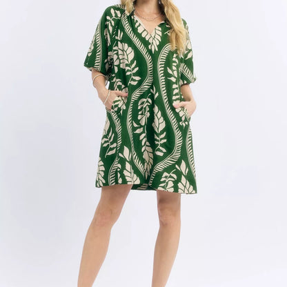 Model wearing a bohemian style cream and green Umgee leafy ogee print mini dress from Solazura Boutique