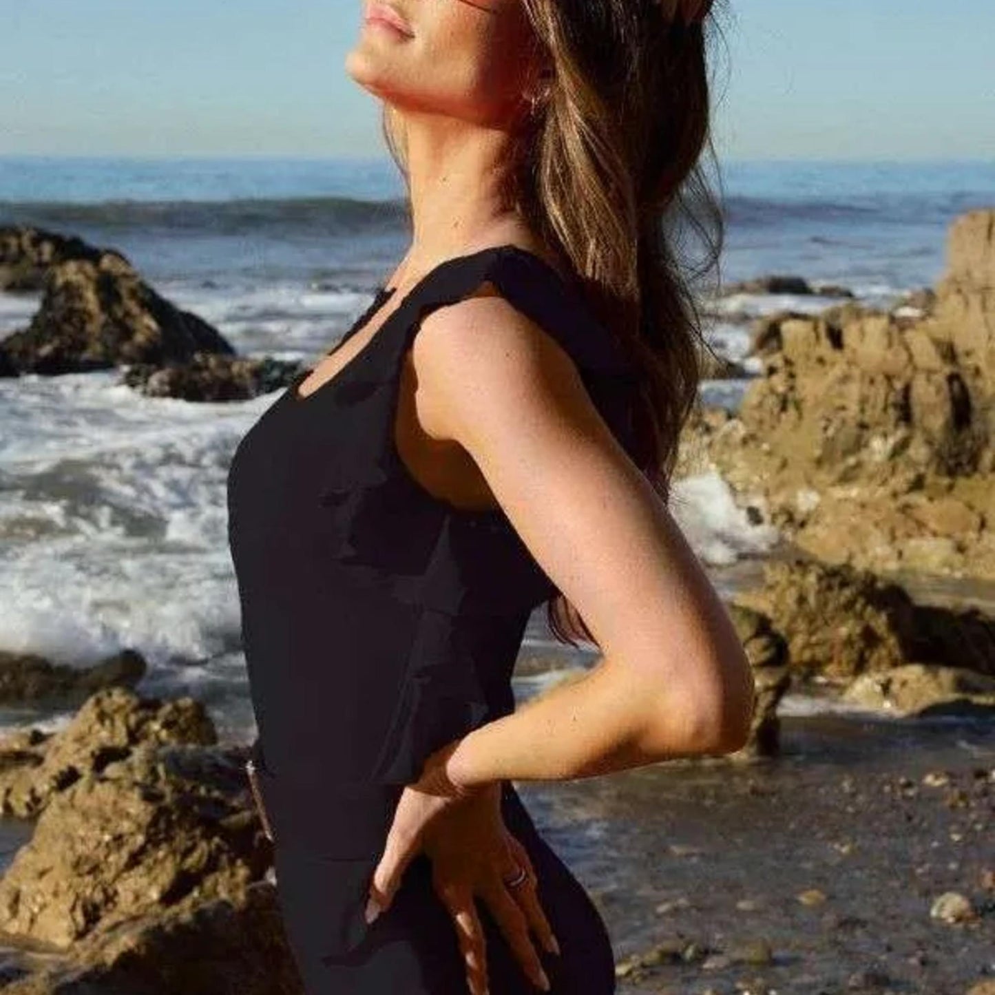 Side profile of the Davi & Dani black ruffle swimsuit highlighting the flattering asymmetric silhouette.