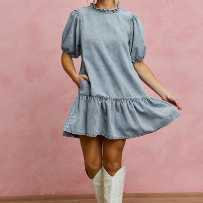 SO ME denim puff sleeve mini dress styled with white knee-high boots.