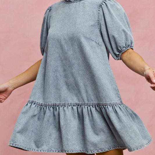 Side profile of the SO ME tiered denim mini dress with ruffle hem detail.
