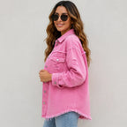 Side view of women's pink distressed denim shacket with relaxed fit and frayed hem