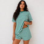 Woman wearing emerald green and white horizontal striped short-sleeve top and shorts lounge set