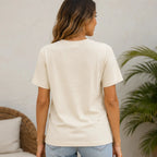 Back view of a woman wearing the natural western graphic t-shirt with a relaxed fit and classic crew neckline.