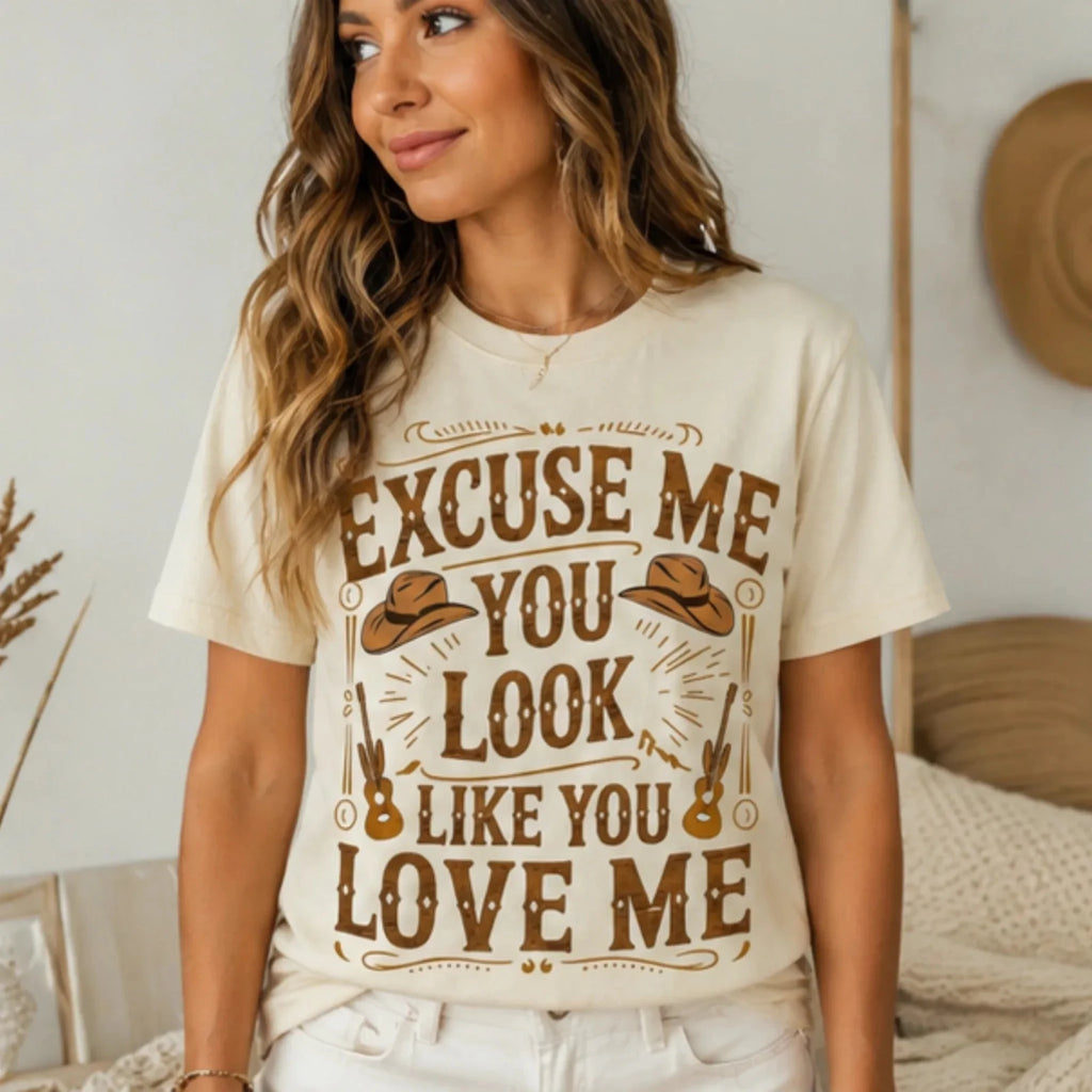 Woman modeling the natural "Excuse Me You Look Like You Love Me" graphic t-shirt with a relaxed casual western-inspired outfit.