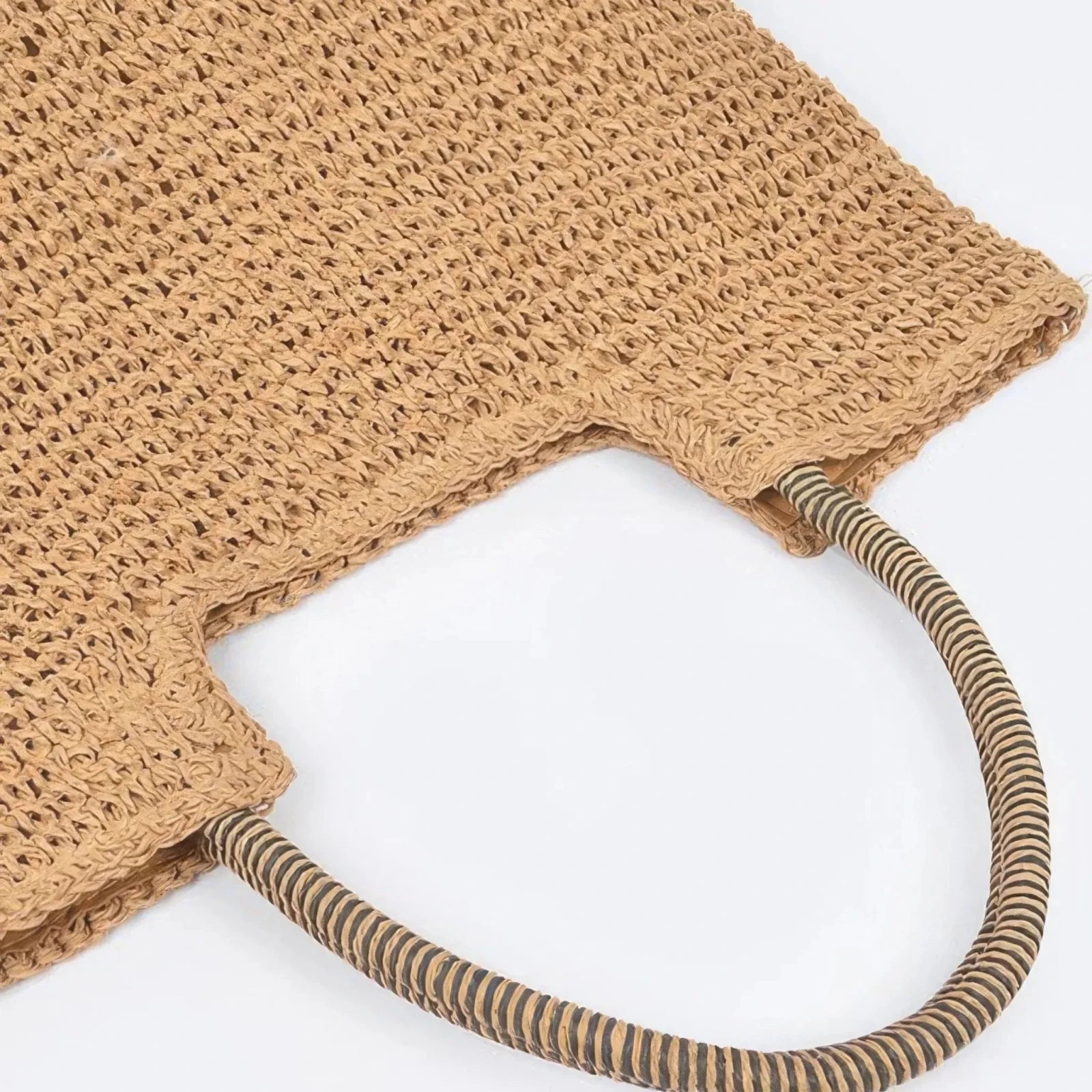 Close-up of the striped shoulder handles and woven texture on a khaki faux straw tote bag.