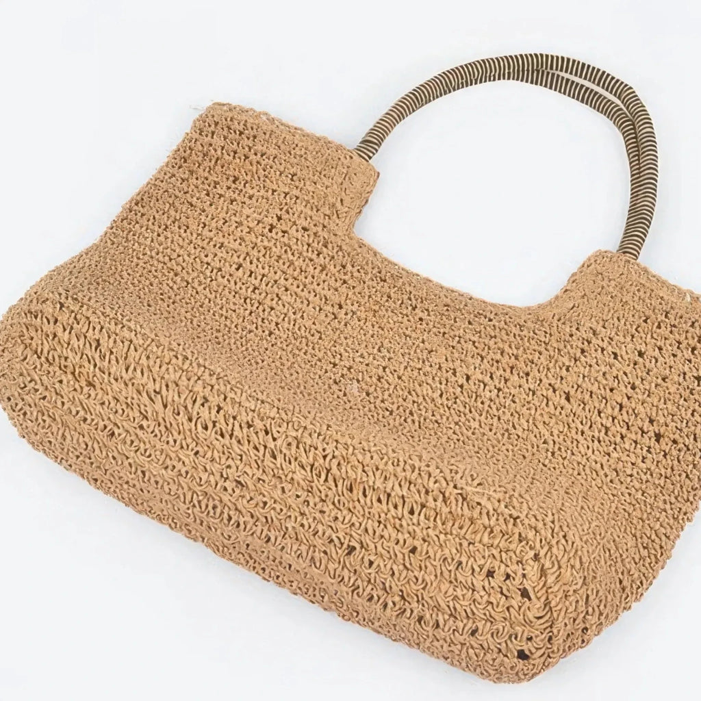 Bottom view of a khaki faux straw tote bag highlighting woven construction and roomy everyday design.