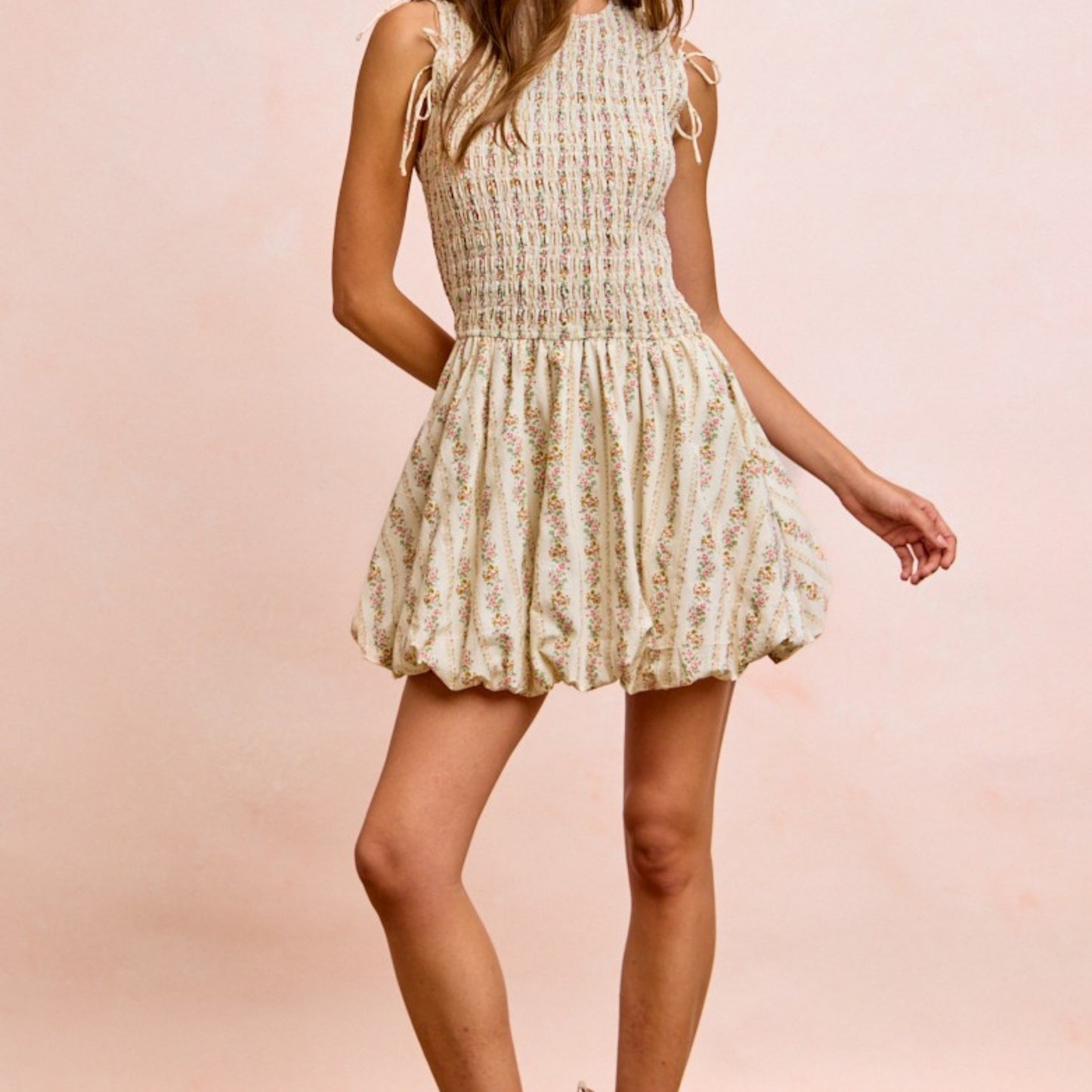 Woman wearing a floral dress against a pink background