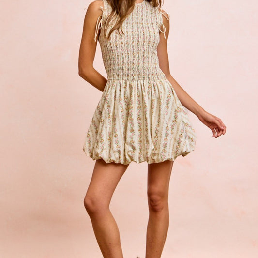 Woman wearing a floral dress against a pink background
