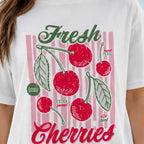 Close-up of the Fresh Cherries vintage cherry graphic print on a white oversized T-shirt.