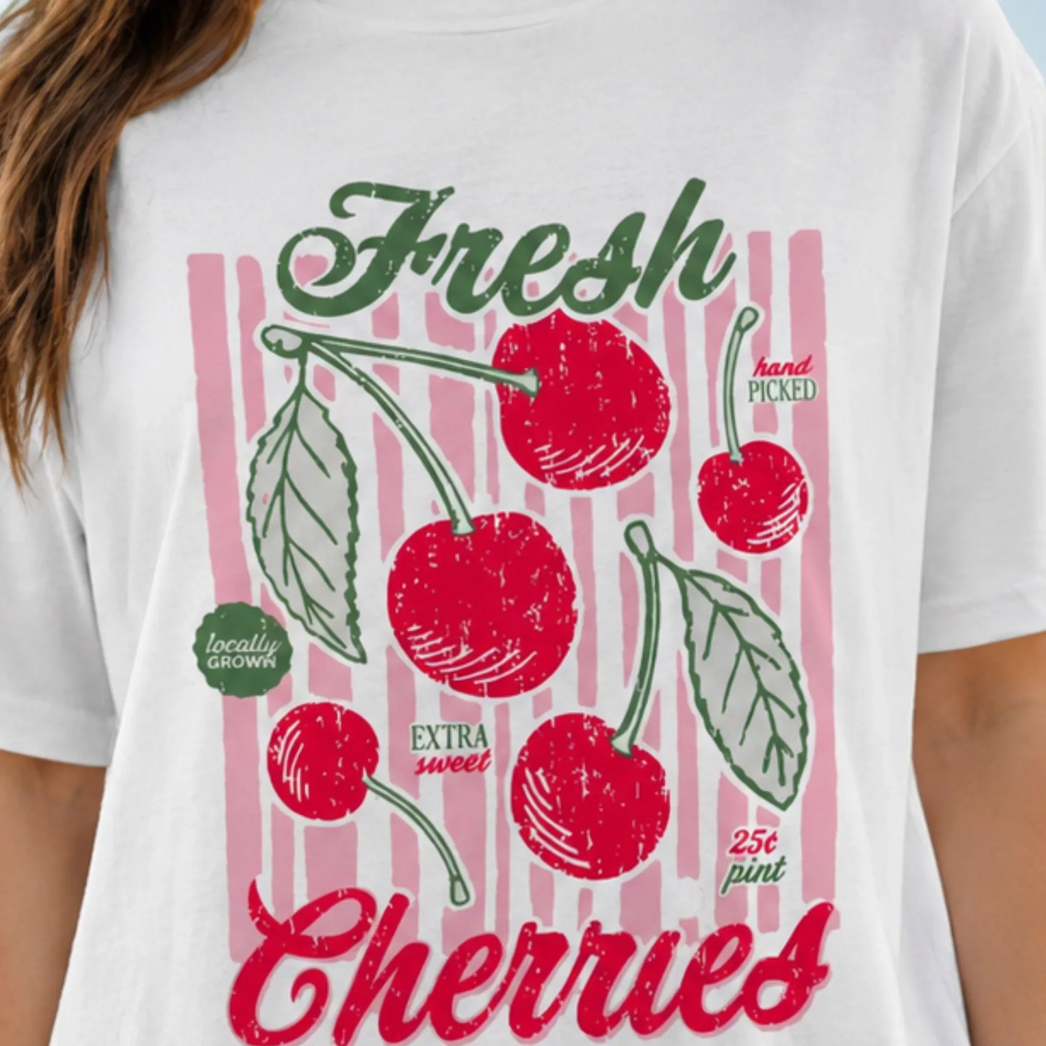 Close-up of the Fresh Cherries vintage cherry graphic print on a white oversized T-shirt.