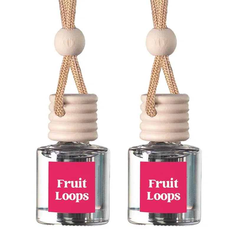 Two small clear glass reed diffusers with pink labels reading 'Fruit Loops' and light wood tops with braided beige cords, shown on a white background.