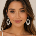 Woman wearing gold rhinestone drop earrings with sparkling baguette-cut crystals, front view.