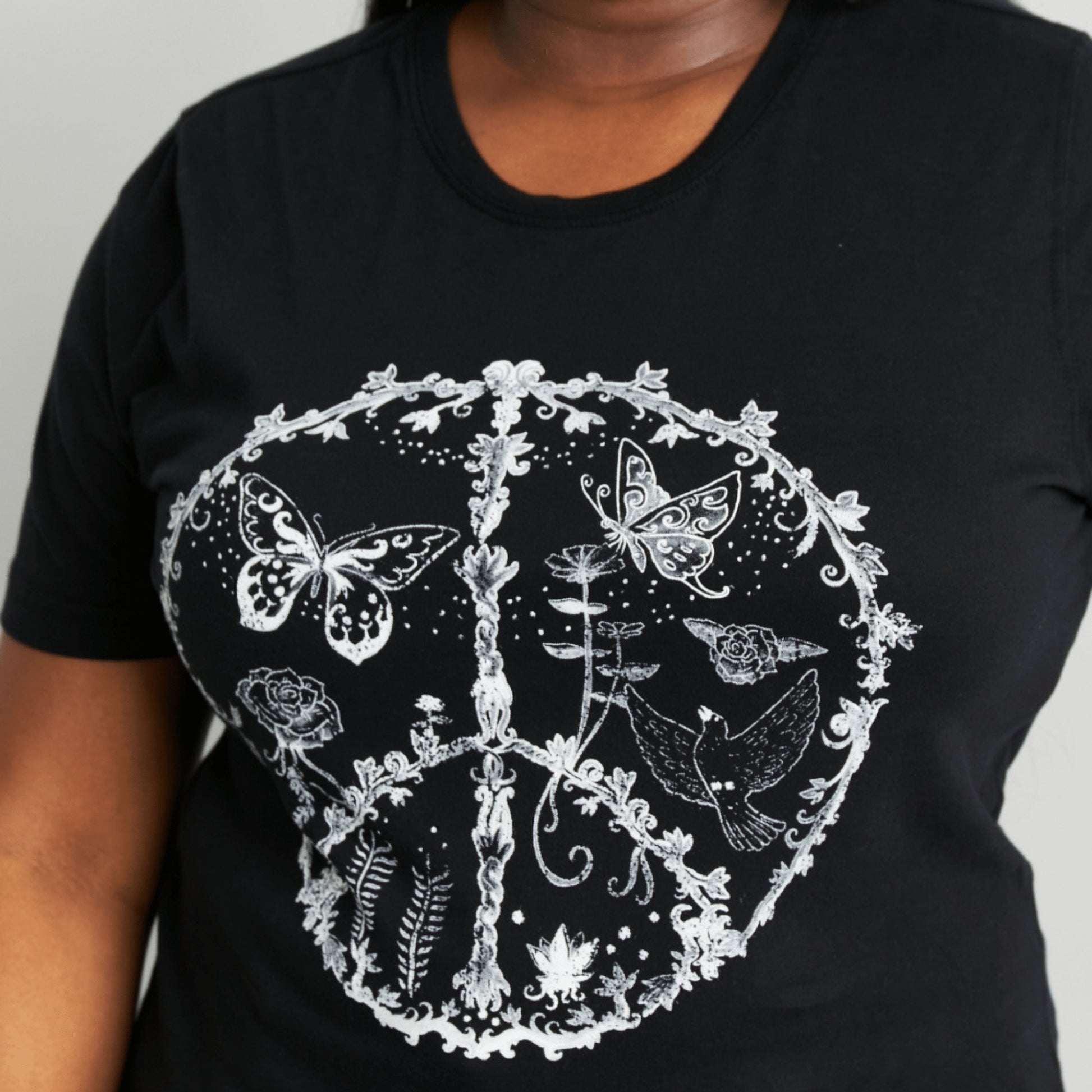 Complete boutique presentation of a black butterfly print tee and light-wash denim.