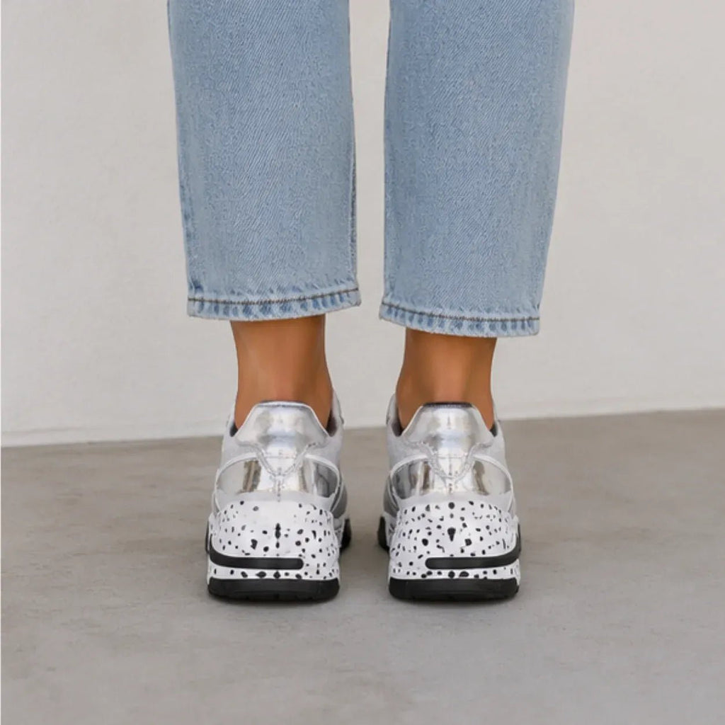 Rear view of women's gray platform sneakers with metallic heel detail and speckled wedge outsole.