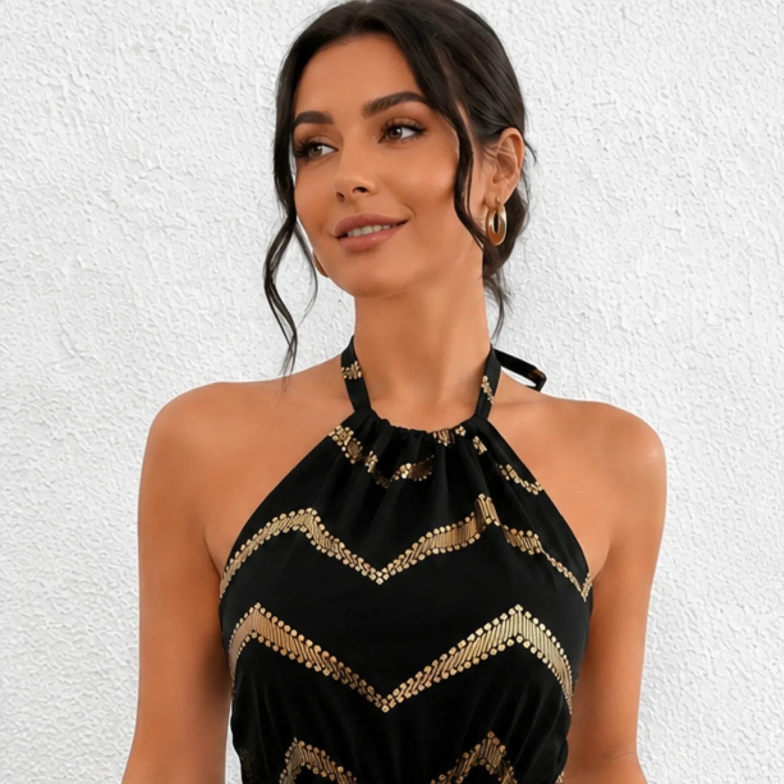 Close-up detail of the Chevron Halter Neck Romper in black highlighting the halter neckline and metallic gold chevron pattern.
