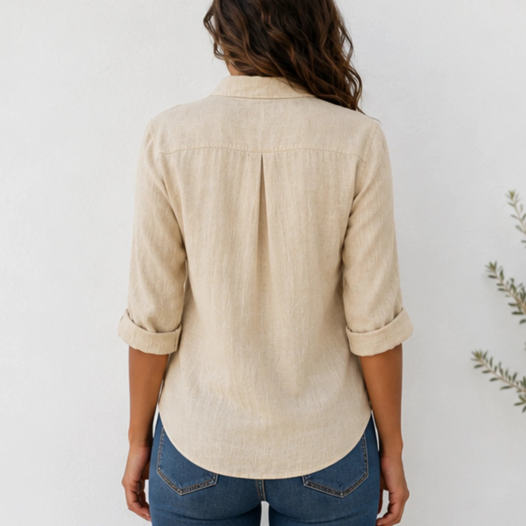 Back view of women's beige linen blend long sleeve collared blouse with relaxed fit and curved hem.