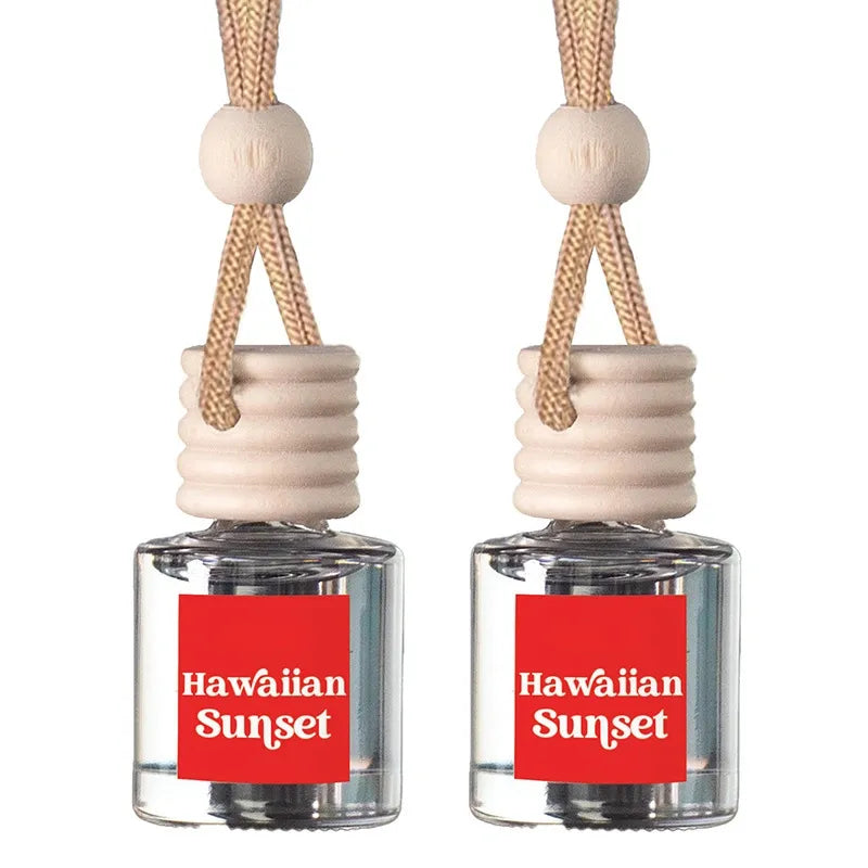 Two matching car air freshener bottles with clear glass bodies, beige wooden diffusers, and beige hanging cords, each labeled Hawaiian Sunset on a red square.