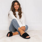 Woman wearing black Heart Plush House Slippers with a cozy casual outfit in a bright indoor setting.