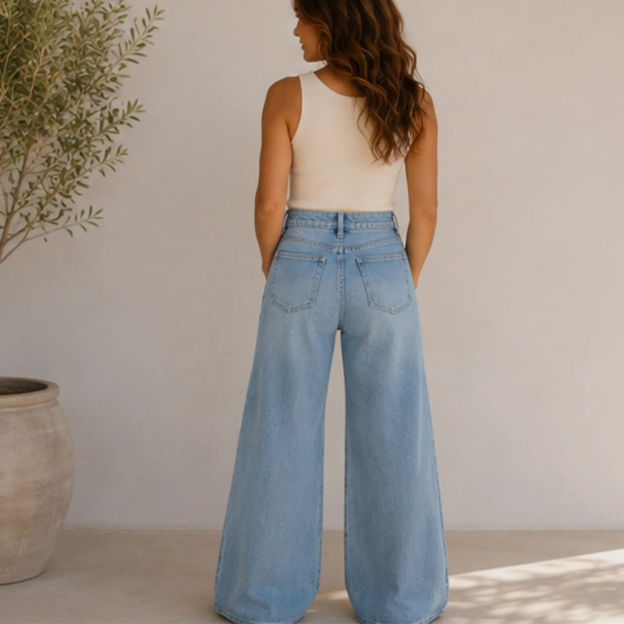 Back view of women's high rise wide leg jeans in light wash denim featuring a high-rise waist, classic back pockets, and a relaxed wide leg fit.