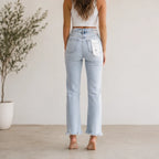 Back view of Women's High Waist Distressed Straight Leg Jeans in light blue with classic five-pocket styling and frayed hems.