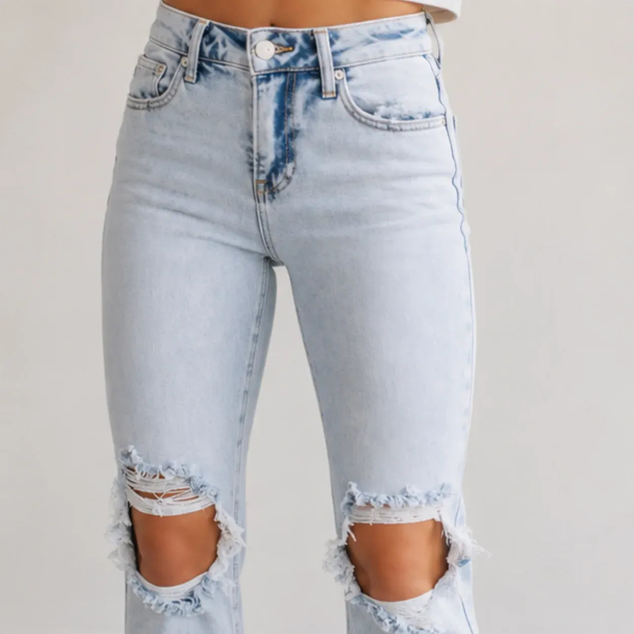 Close-up of Women's High Waist Distressed Straight Leg Jeans in light blue highlighting ripped knee detailing, premium denim, and distressed finish.