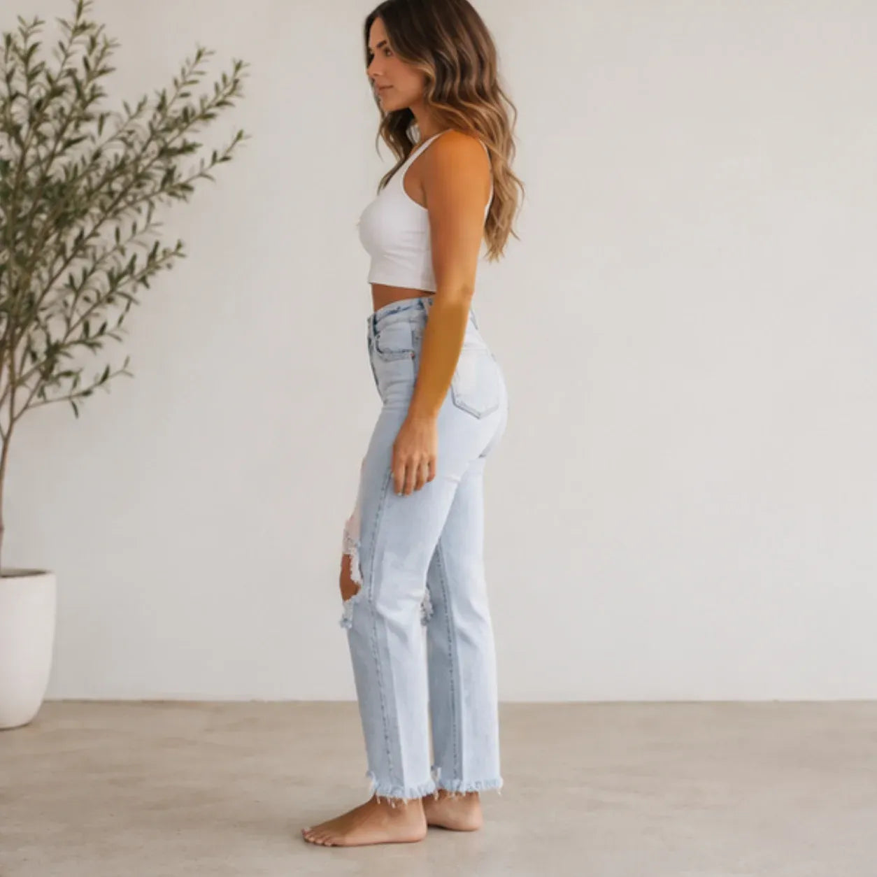 Side view of Women's High Waist Distressed Straight Leg Jeans in light blue featuring a flattering high-rise waist and distressed straight-leg design.