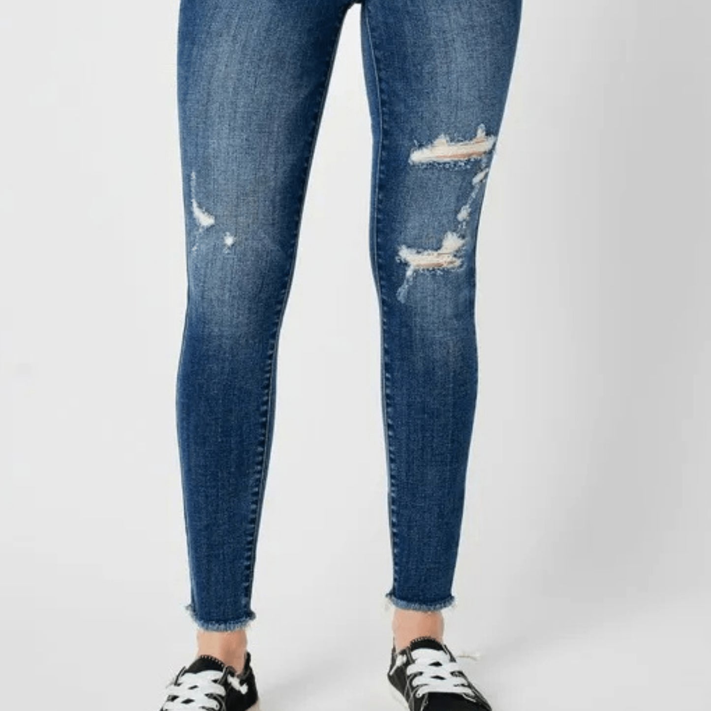 Close-up of the high-waist fit and distressed denim texture.