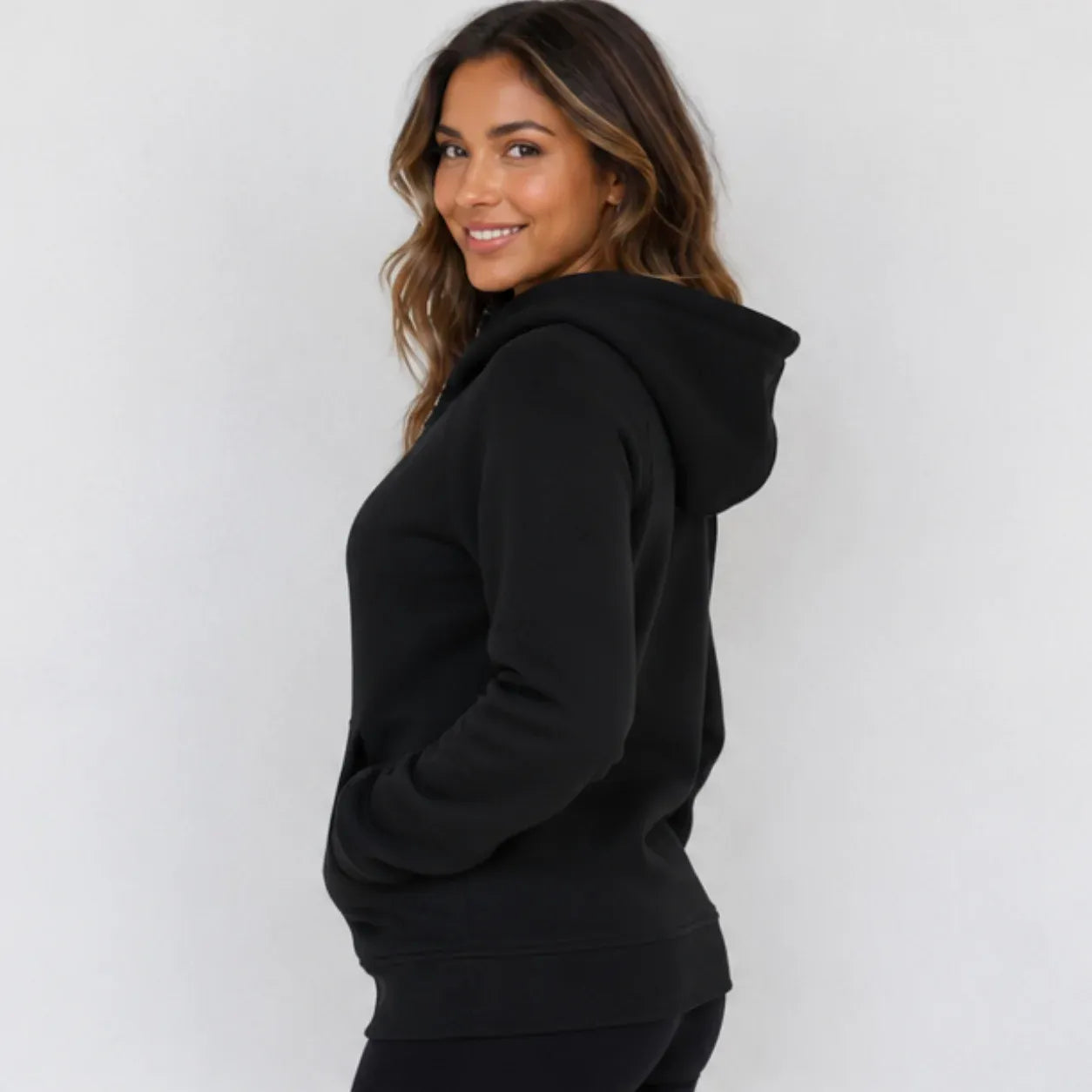 Side view of women's black hooded fleece-lined zip-up sweatshirt showing hood and relaxed fit