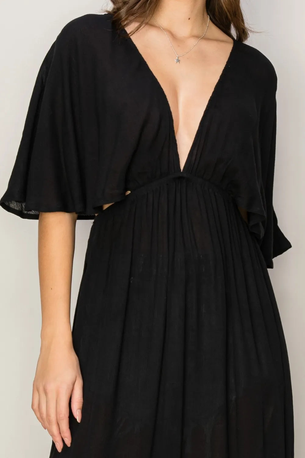Lifestyle view of the HYFVE Black maxi dress styled for a sophisticated beach look.
