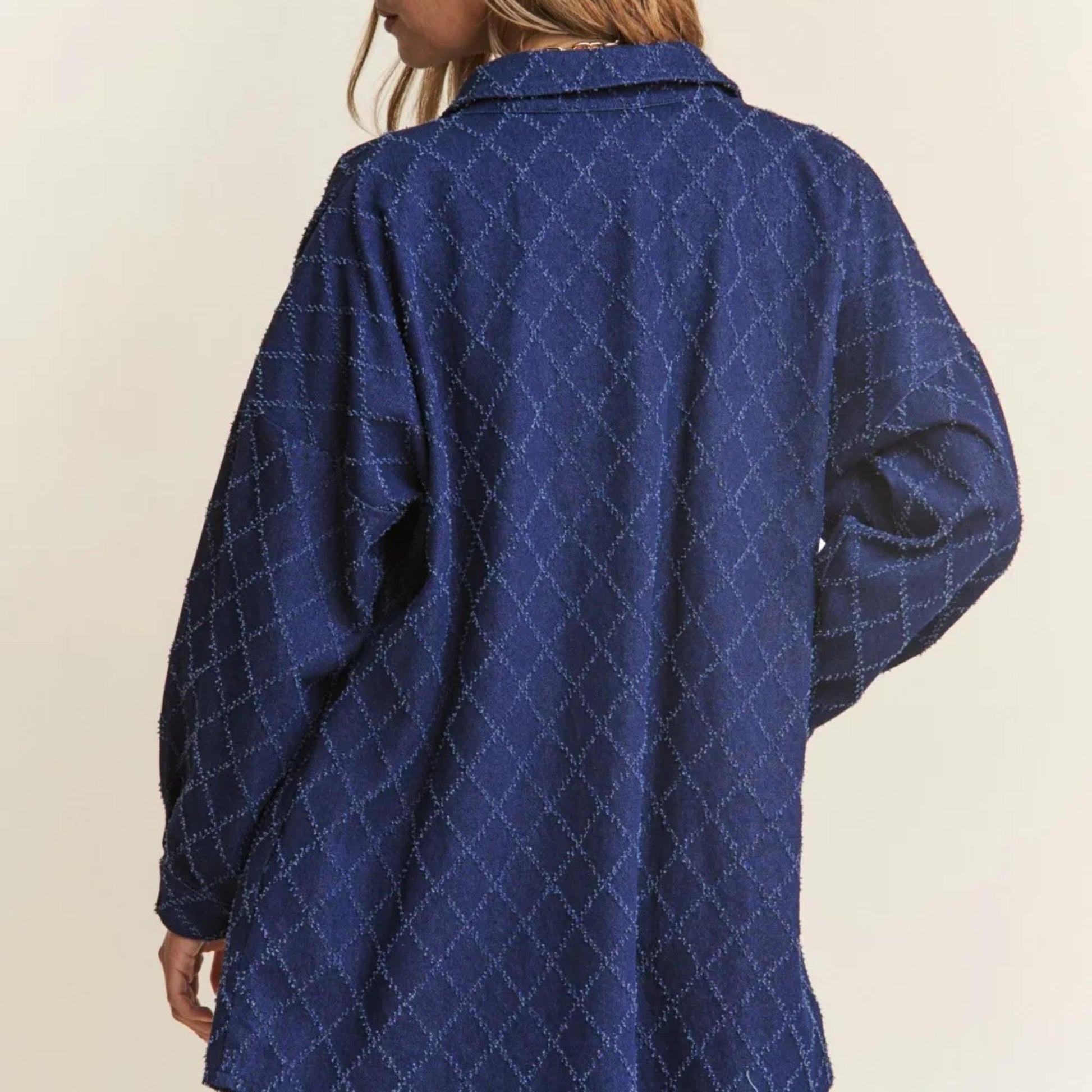 Blue diamond patterned denim worn by a person on a beige background
