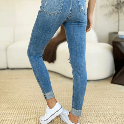 Model wearing Judy Blue cuffed skinny jeans with white sneakers.
