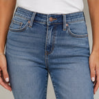 Close-up of Judy Blue Full Size Mid Rise Rigid Magic Release Hem Jeans featuring the mid-rise waistband, button closure, pockets, and premium denim wash.