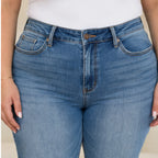 Detailed close-up of Judy Blue Full Size Mid Rise Rigid Magic Release Hem Jeans highlighting the waistband, button closure, stitching, and medium wash denim.
