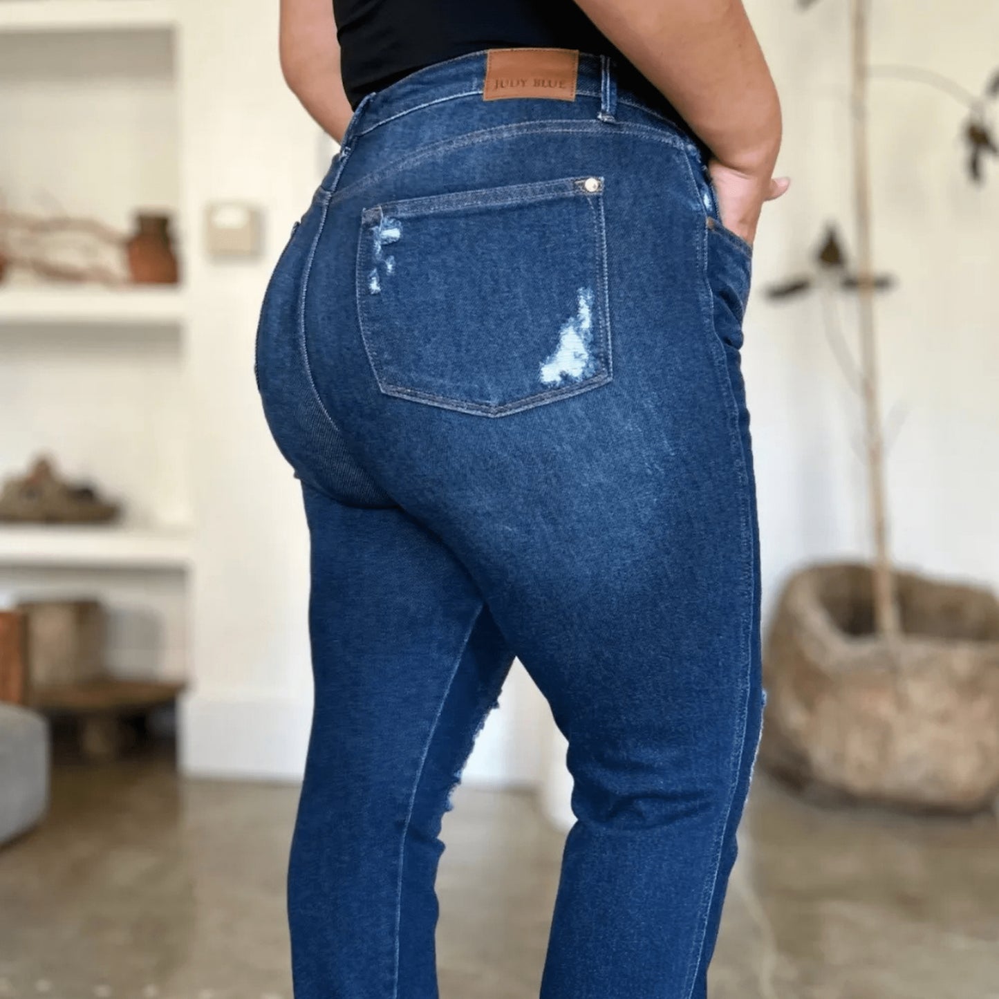 Final view of Judy Blue heavy destroy jeans styled with a black tank top.