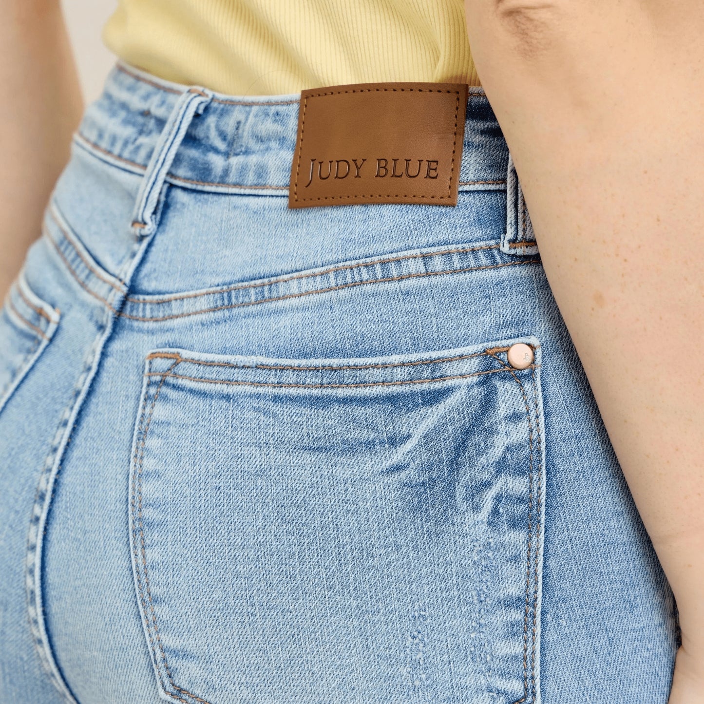 Close-up of the Judy Blue label and hardware on vintage wash skinny denim.