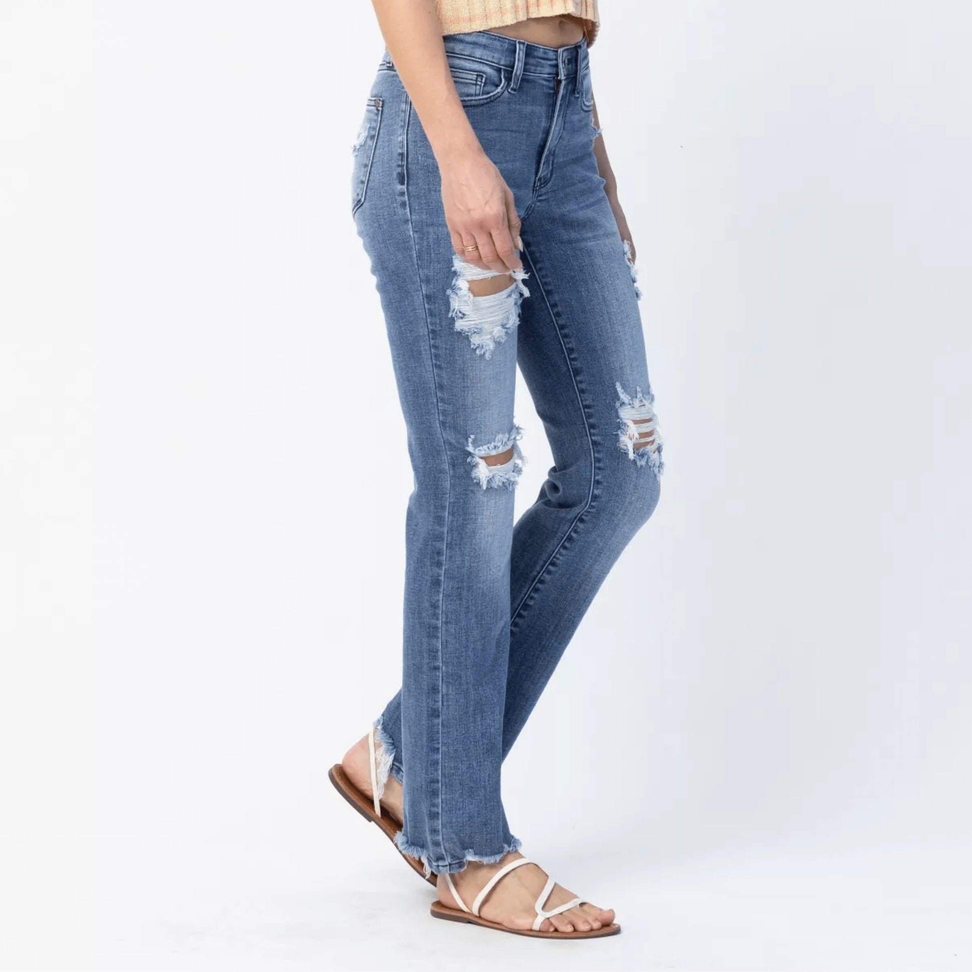 Side view of Judy Blue destroyed straight jeans showing the raw hem and fit.