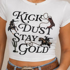 Close-up of the Kick Dust Stay Gold Western Graphic Crop Tee highlighting the vintage Western graphic with cowboy, horse, boot, rope, cactus, and bold lettering.