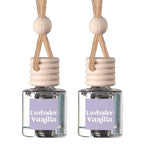 Two lavender vanilla reed diffusers with clear glass bottles, light wood caps, and beige hanging cords on a white background.