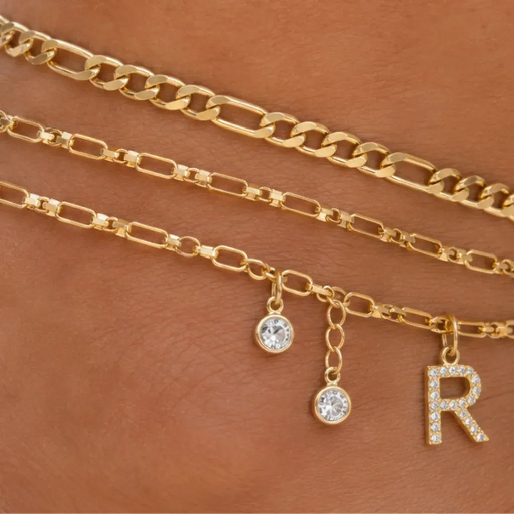 Close-up of the Layered Initial Gold Anklet featuring a sparkling letter charm, crystal accents, and polished gold chain details.