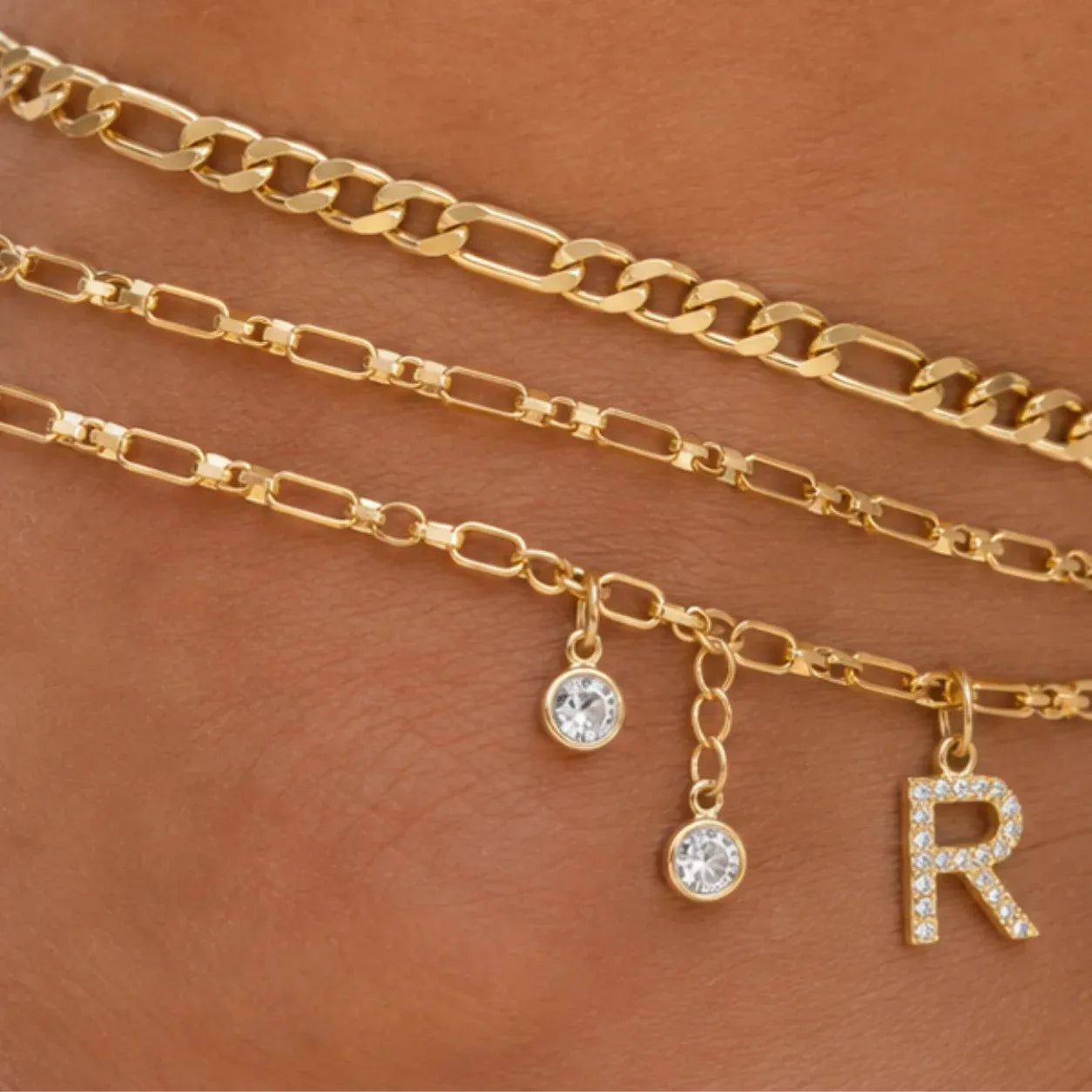 Close-up of the Layered Initial Gold Anklet featuring a sparkling letter charm, crystal accents, and polished gold chain details.